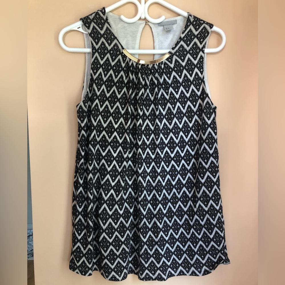 Black and white tank blouse with gold me tail detail in front.